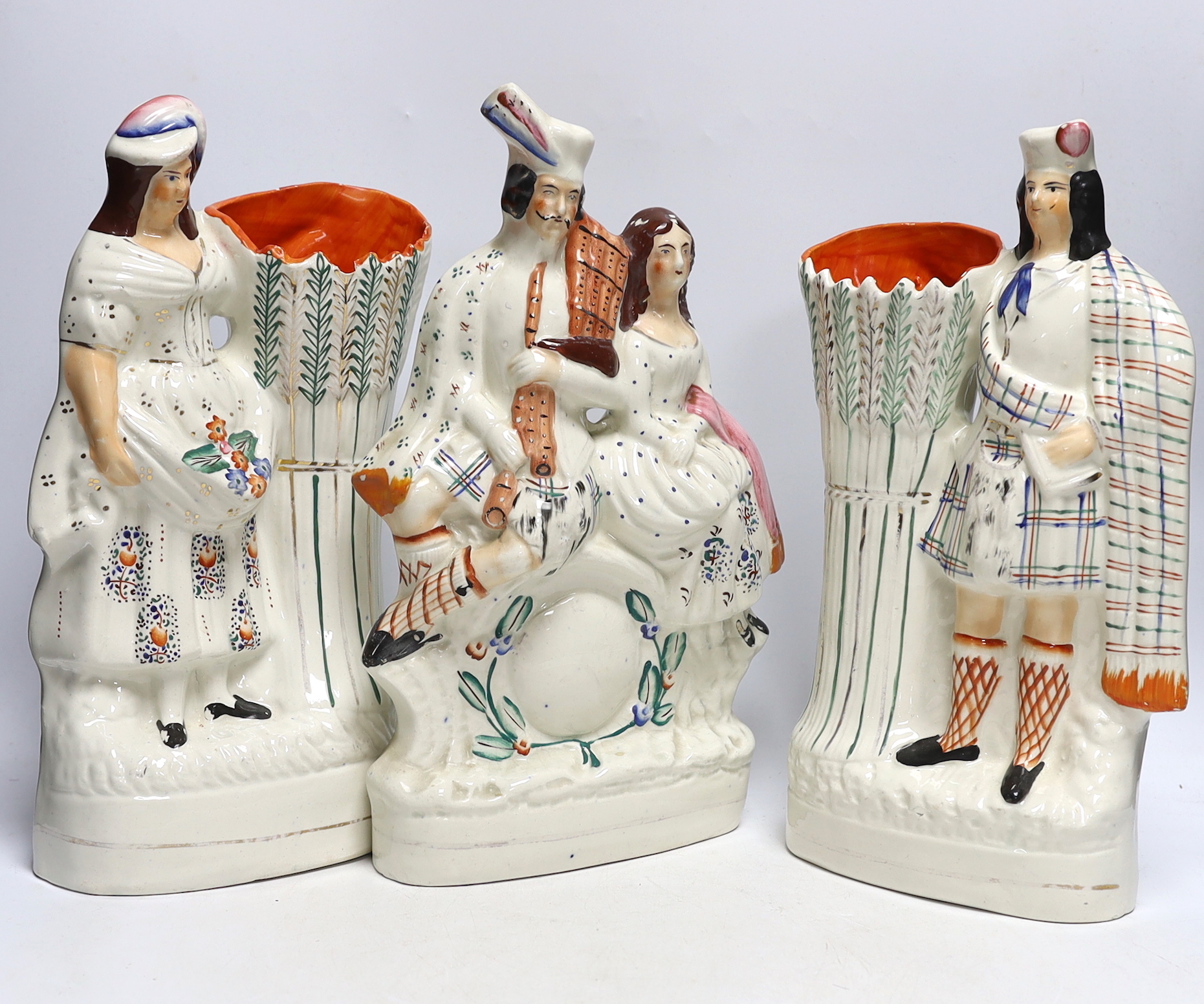 Four Staffordshire figure groups; a Crucifixion stoup, a pair of vases, a Scottish group and two related reference books, tallest 34cm